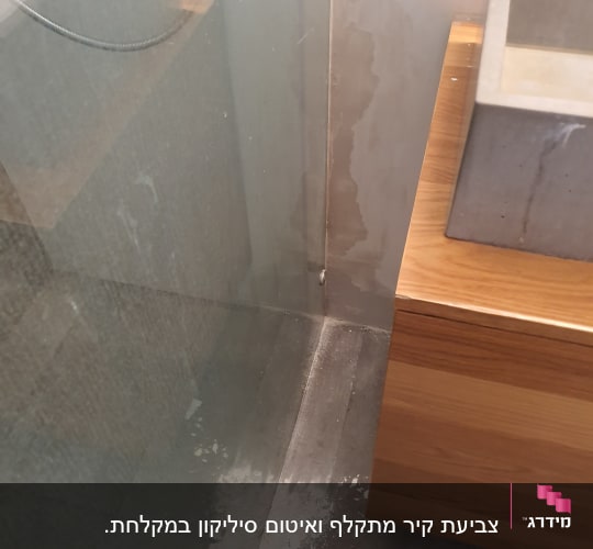 כתמי צבע לבן על רצפת אריחים ליד קיר